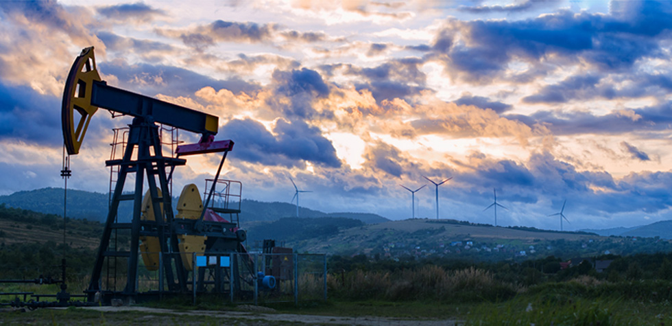 Pumpjack with clouds and wind turbines inert background