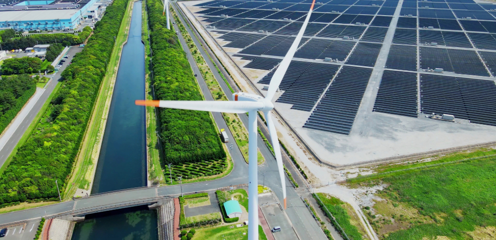 Wind turbine next to solar panel field