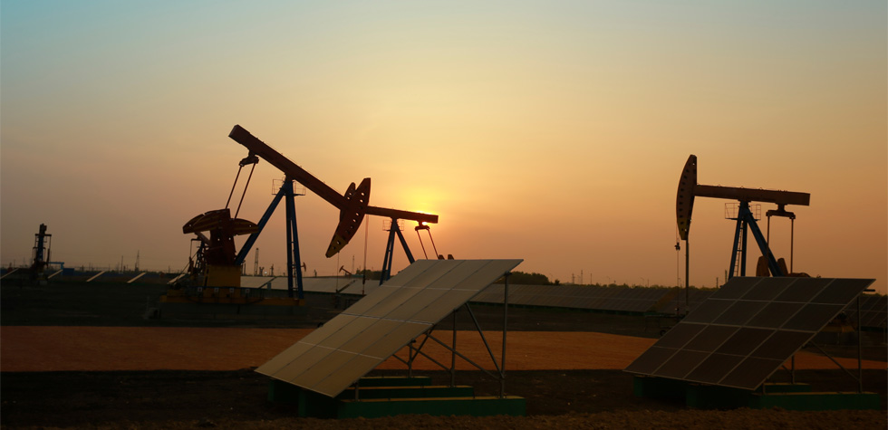 Photograph of a solar panel and some pumpjacks